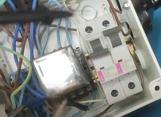 A person is checking the connection of a circuit breaker panel