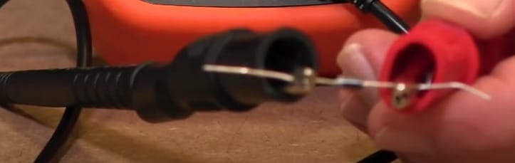 A person is connecting the multimeter's probe into a diode