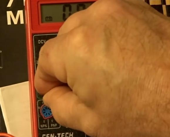 A person using a cen tech multimeter