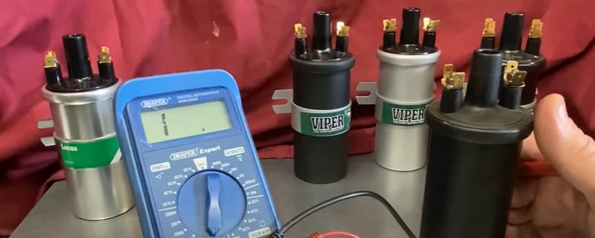 A person diligently testing coil pack efficiency with a multimeter