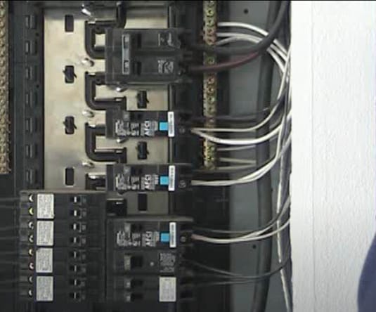 An open electrical panel showing different amperage of circuit breakers