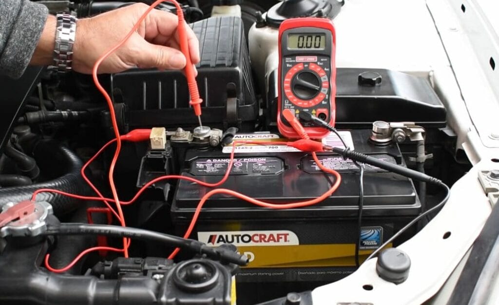 A man is using a multimeter to check the battery in a car for any signs of drain