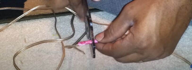 A person is holding a plier and a wire