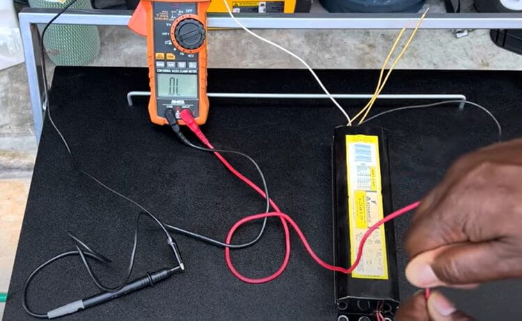 A person is using a multimeter to test a wire