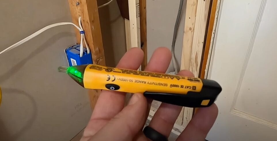 A person holding a non-contact voltage tester