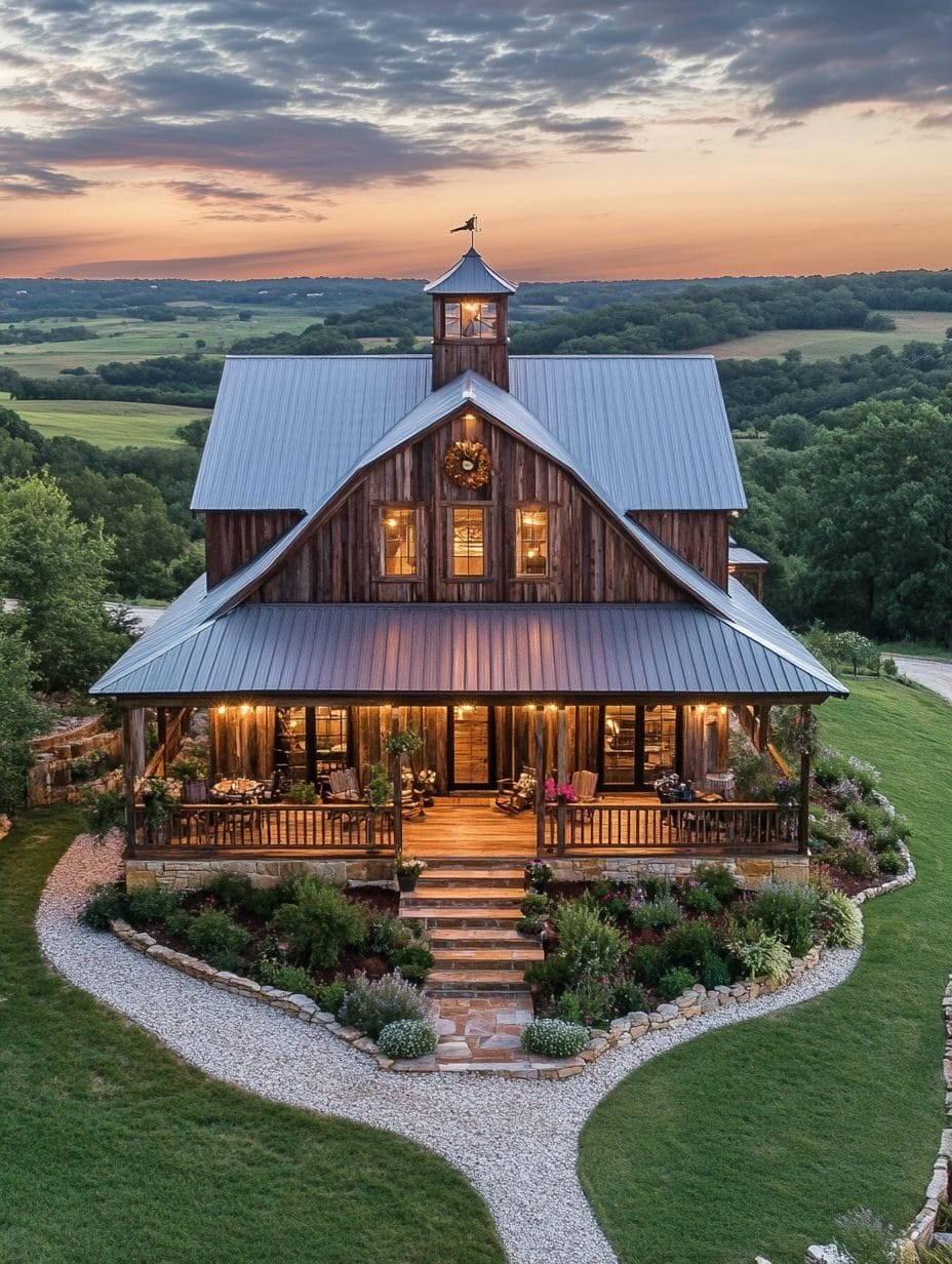 A two-story rustic wooden house with a metal roof, large porch, and surrounded by landscaped gardens, set in a rural area at sunset.
