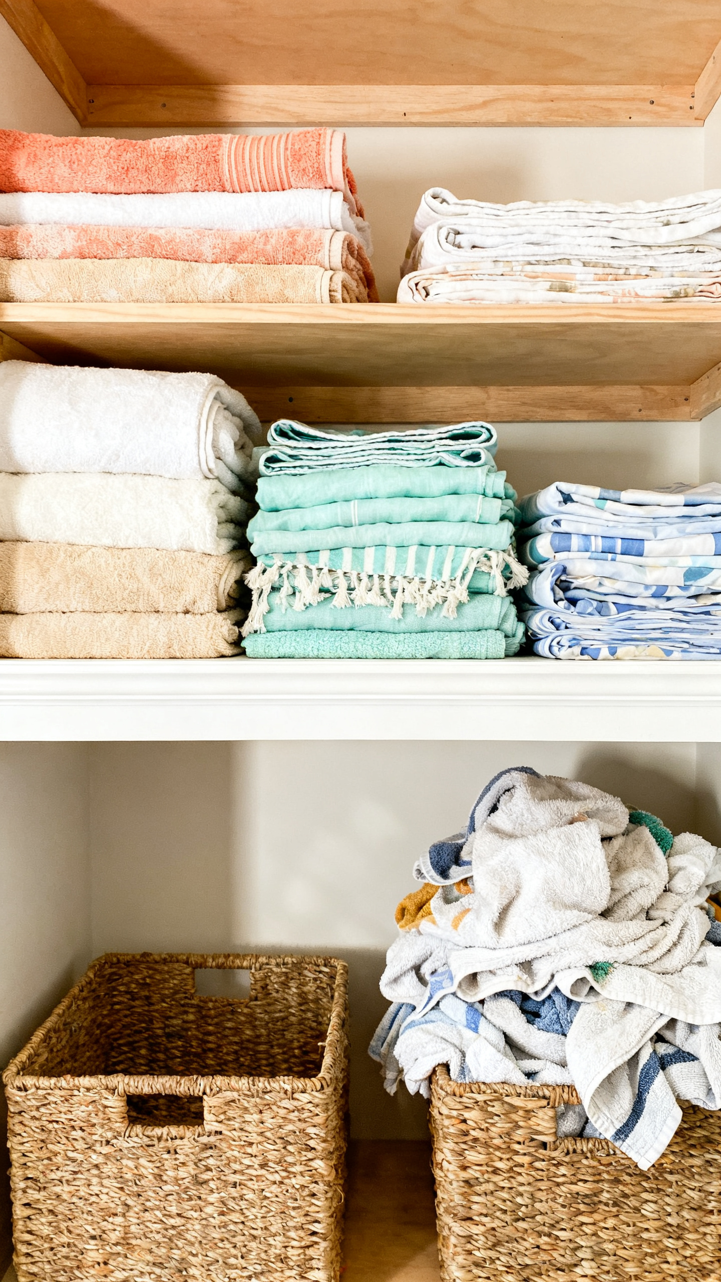 Summer decluttering checklist with folded beach towels and linens sorted in organized storage bins