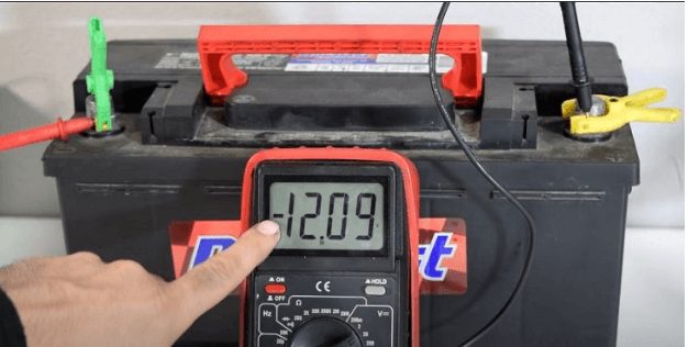 car battery test by mechanic with multimeter