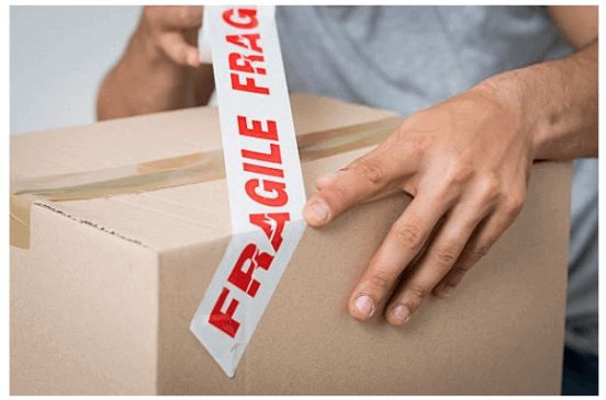 man tagging box with fragile label