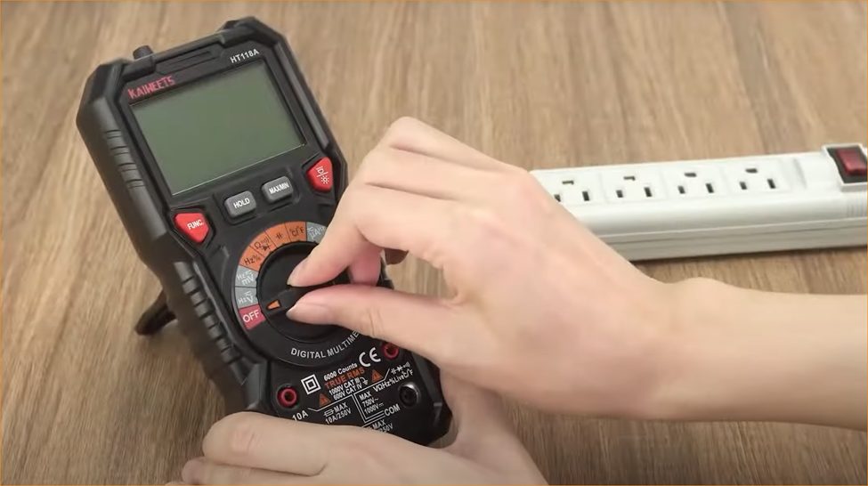 a hand setting up the multimeter