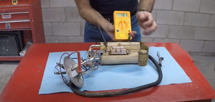 mechanic measuring current of fuel gauge using multimeter