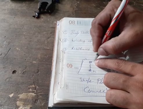 mechanic recording the readings on notebook