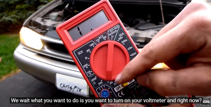 mechanic turning on the voltmeter