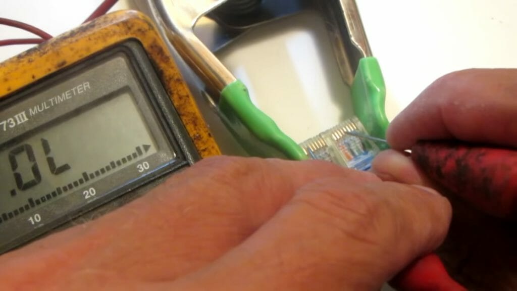 technician testing ethernet cable with multimeter