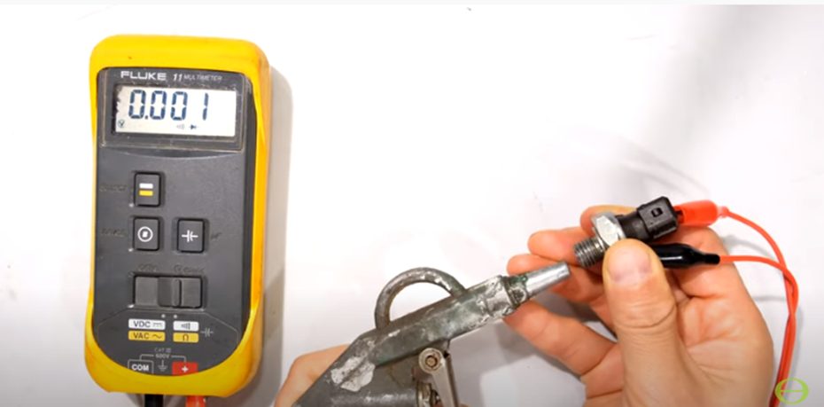 technician testing oil pressure switch with fluke multimeter at a 0.001 reading