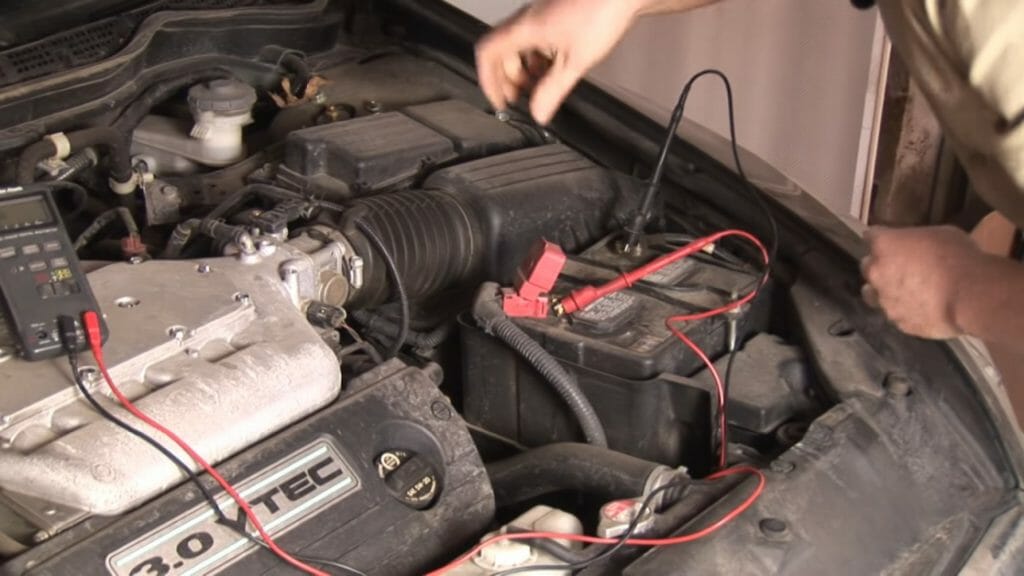 mechanic connecting multimeter probes to car battery