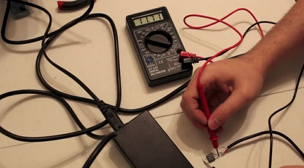 man connecting the multimeter lead to the regulator