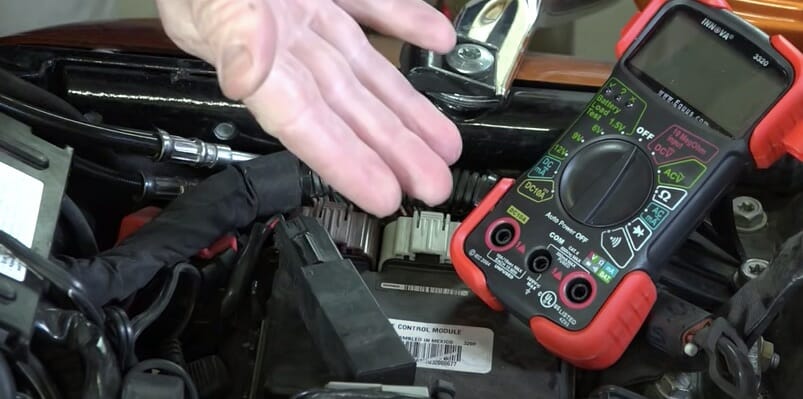 preparing multimeter for testing motorcycle battery