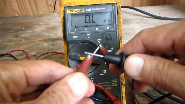 technician holding red and black probe of multimeter