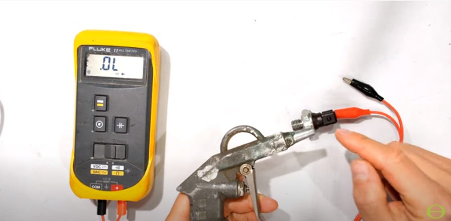 technician testing oil pressure switch with fluke multimeter