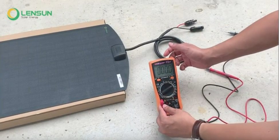 man testing solar panel with a multimeter