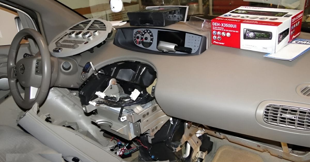 A dismantled speaker on the dashboard area of a car