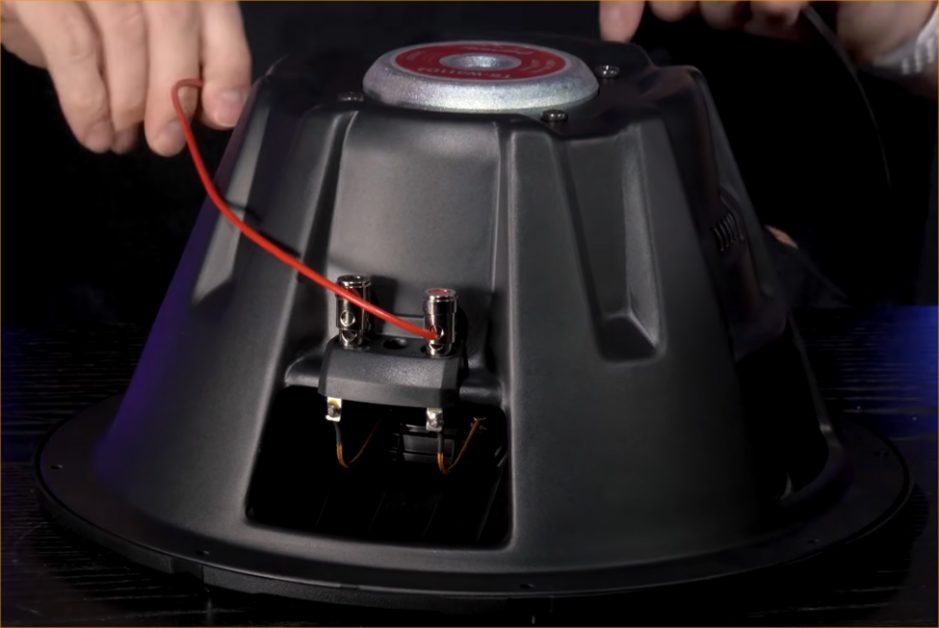man connecting the red wire of the speaker
