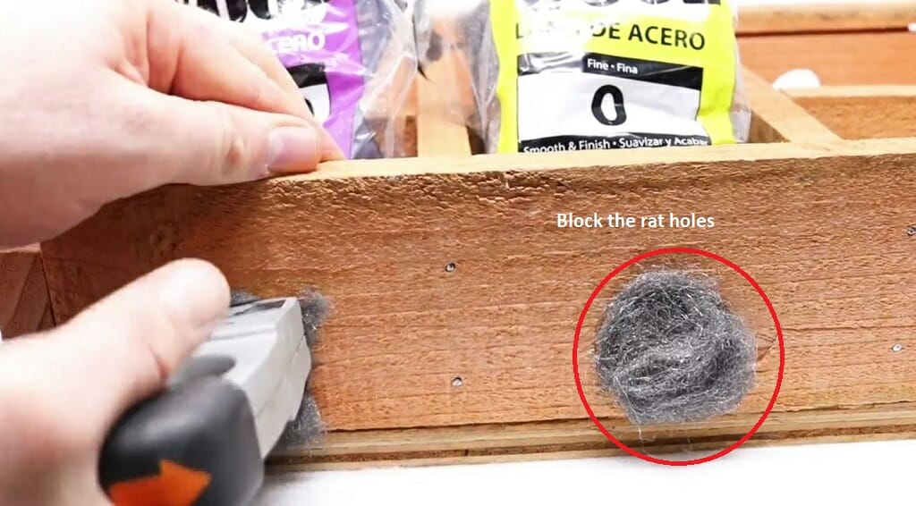 man blocking hole of a box to trap mouse