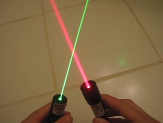 man holding both a green and red laser lights