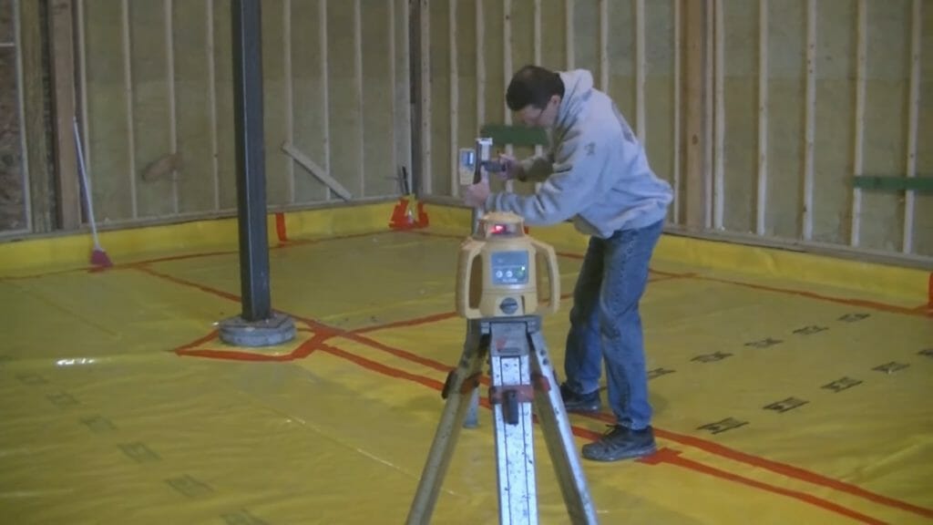 man standing and setting up another laser device