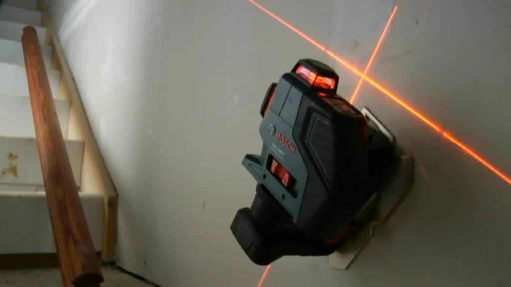 red laser level mounted at the wall