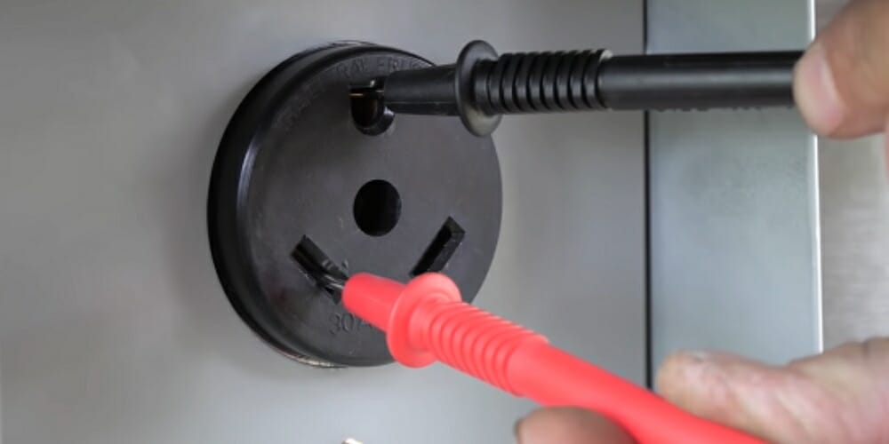 rv outlet with inserted multimeter's red and black probes