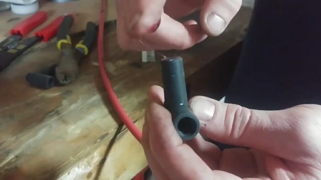 man sliding the spark plug terminal into the plug boot