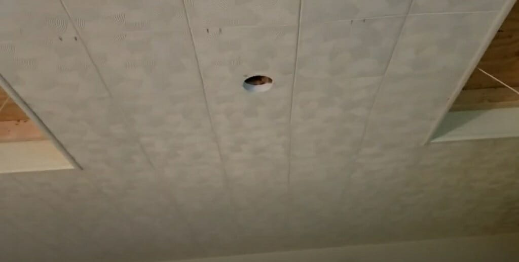 cutting a hole for the light fixture on the ceiling