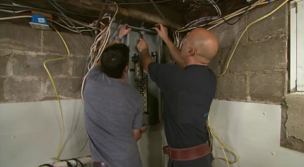 two electrician installing switch box at the basement