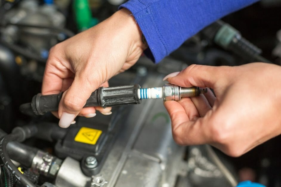 woman changing car's spark plug