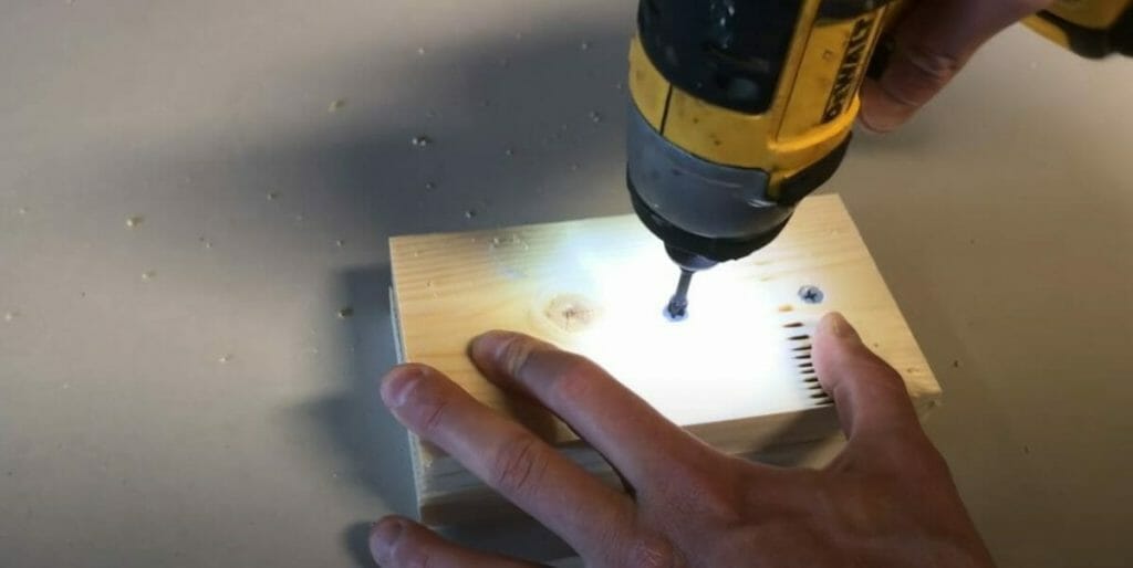 drilling a hole on the wood plank