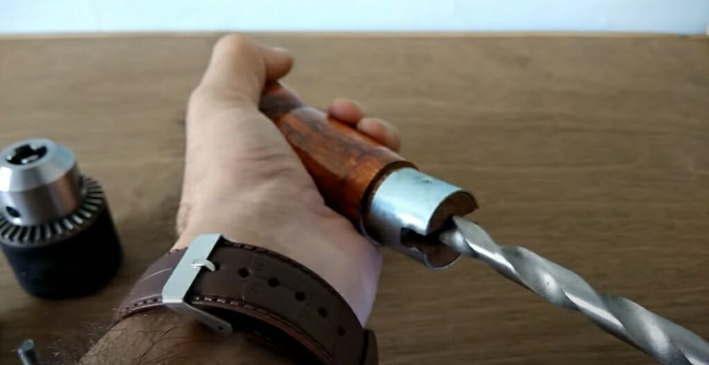A hand holding a drill bit