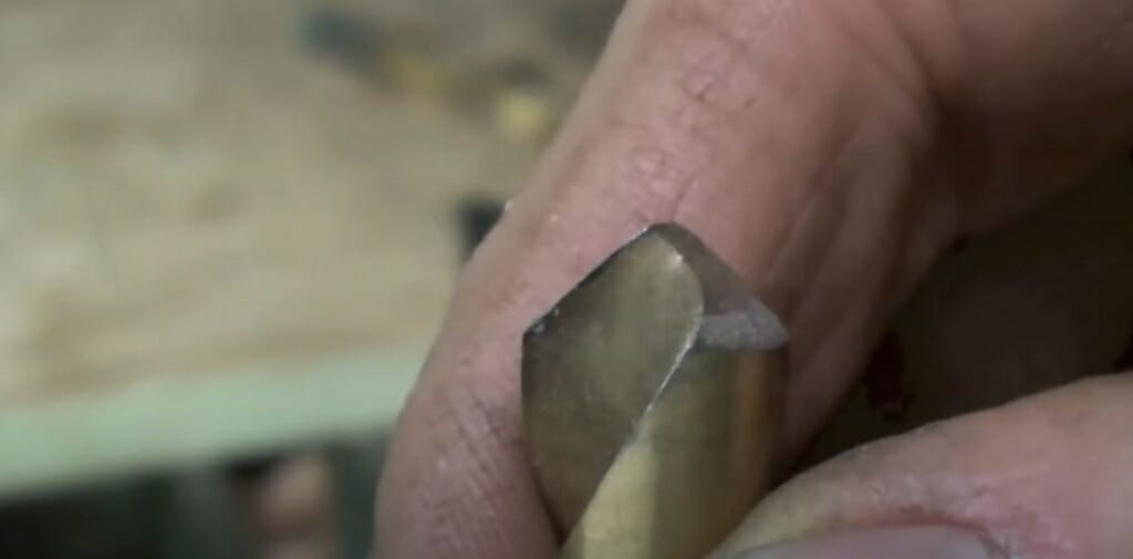 A close up look of a person's hand showing the drill bit's tip
