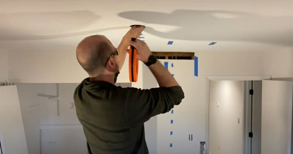 man fixing wire on the ceiling