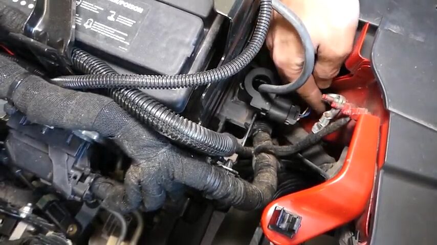 A mechanic replacing a faulty battery sensors