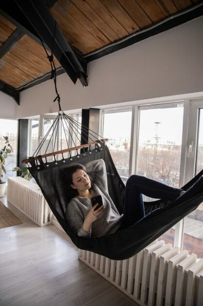 woman on a hammock tied to a roof beam