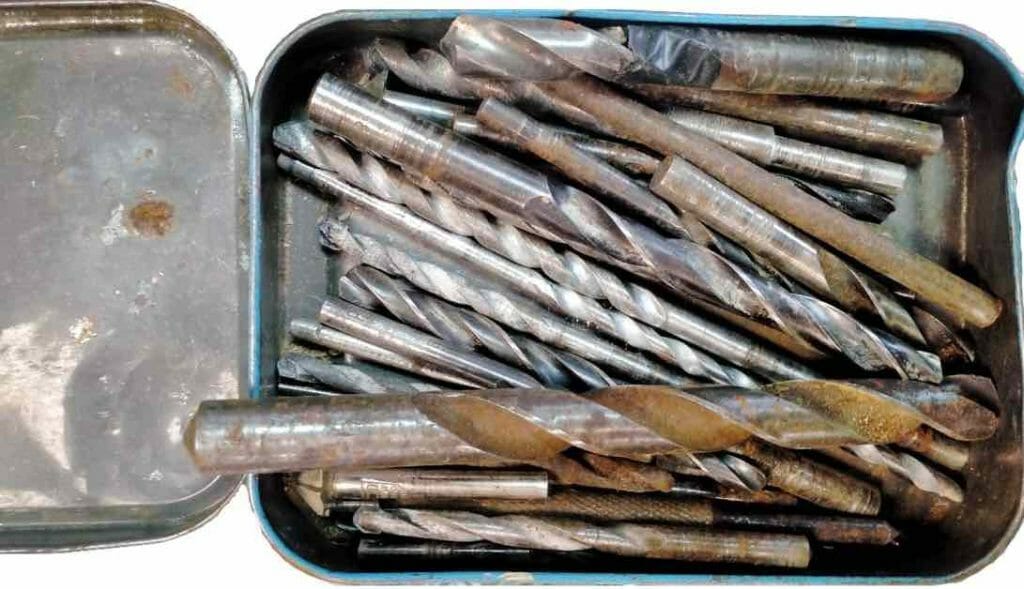 a tin container of mixed drill bits