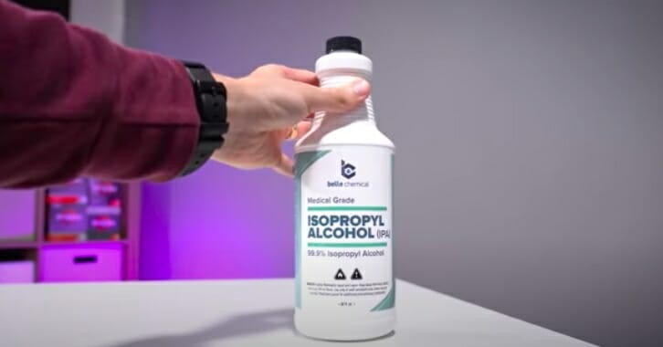 hand holding an isopropyl alcohol bottle