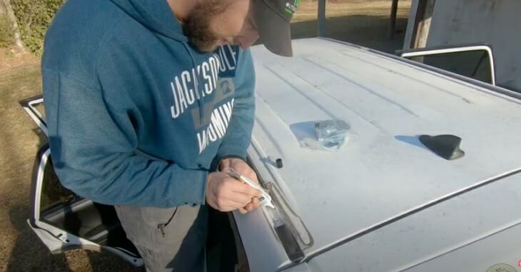 man applying no-drill paste on car roof