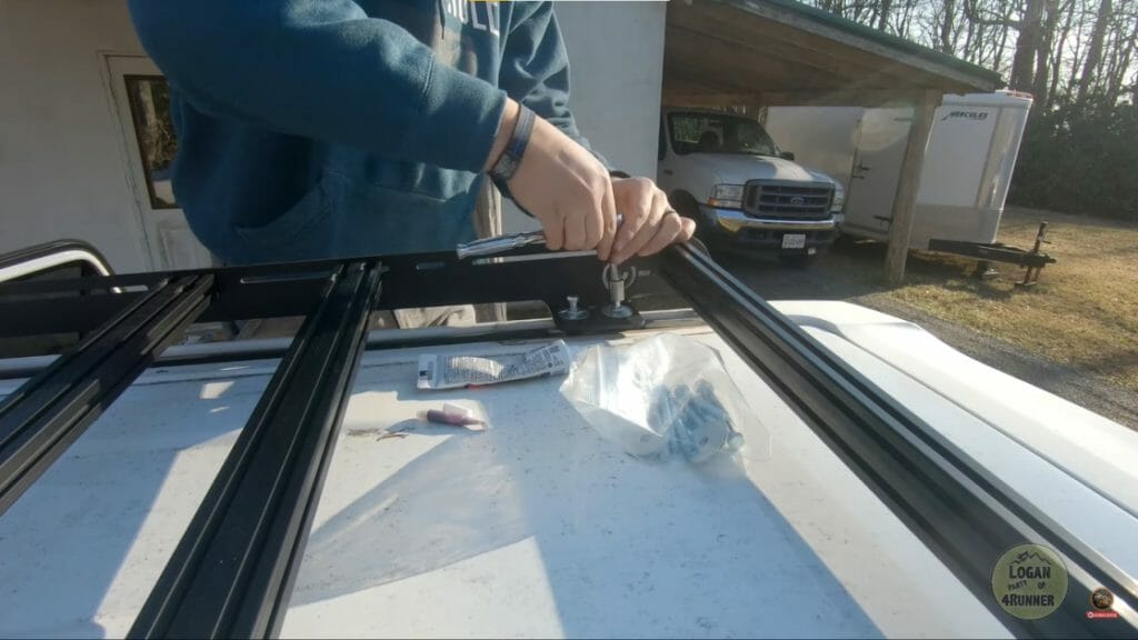 man installing the mounting bracket at the top of the car