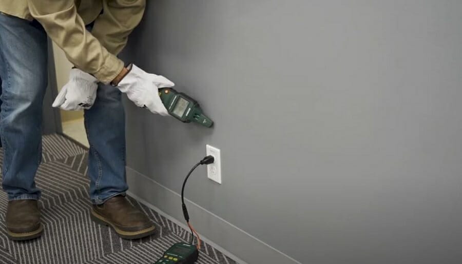 man using cable finder on the wall
