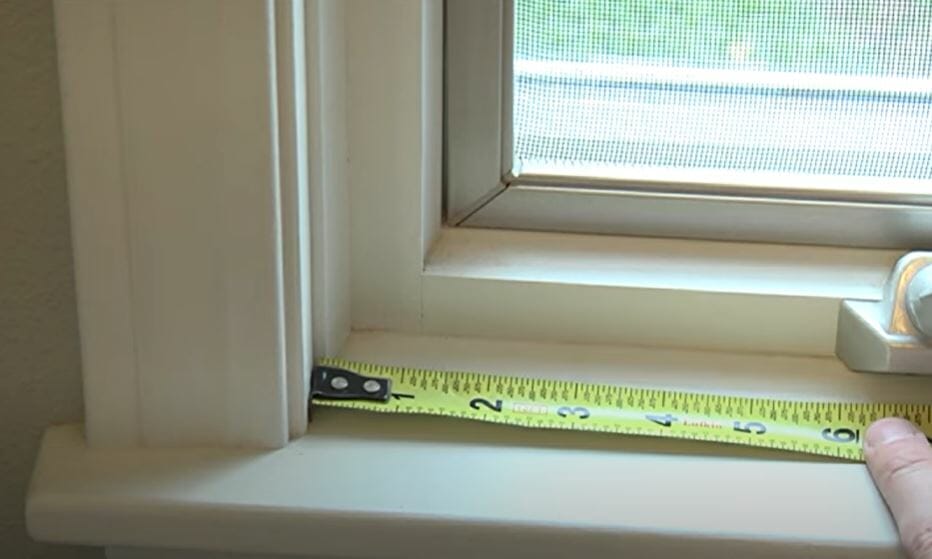 measuring the window with measuring tape