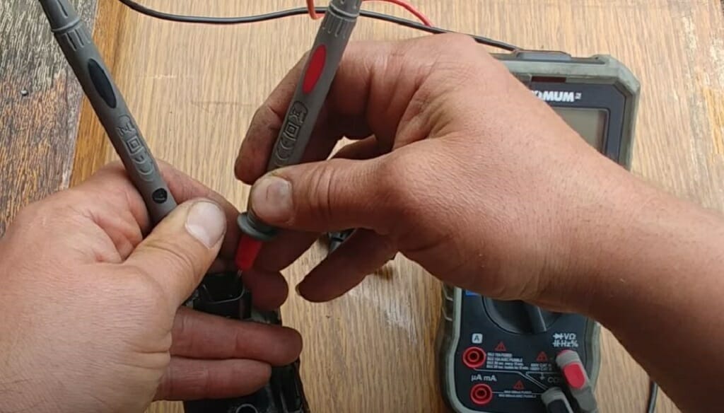 pointing the multimeter's probe to the purge valve