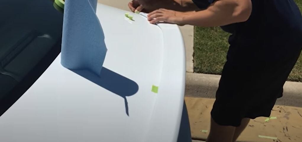 placing the spoiler on the deck lid and hold it tightly